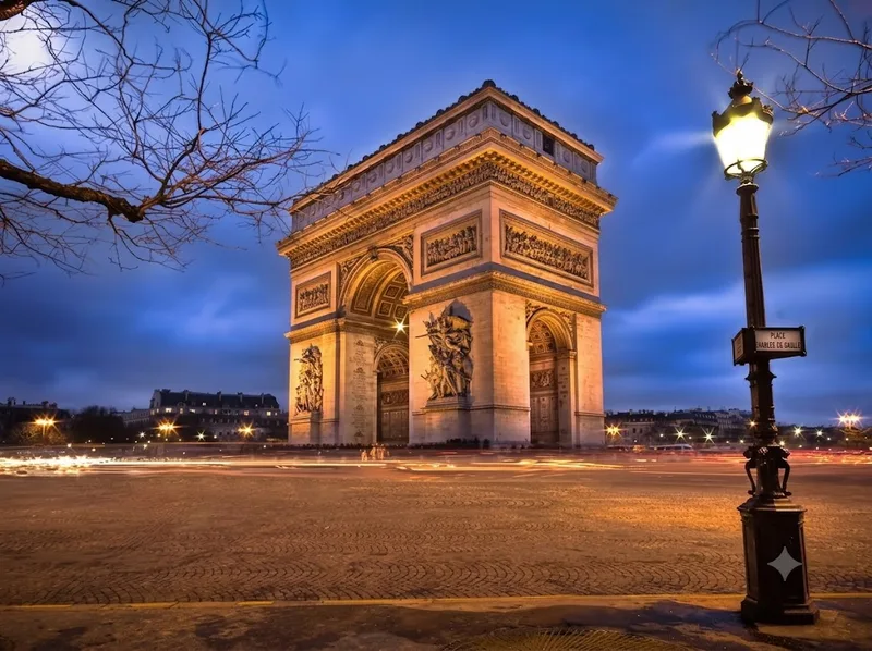 Khải hoàn môn Paris nổi bật dưới ánh hoàng hôn và đèn đêm